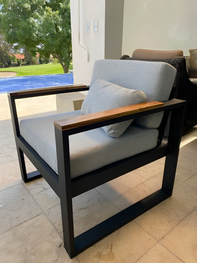 Sillón de exterior con estructura de metal y detalles de madera maciza.